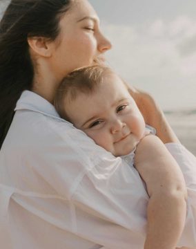 Tender moment between mother and baby at sunny Delray Beach.
